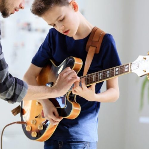 criança tocando Guitarra