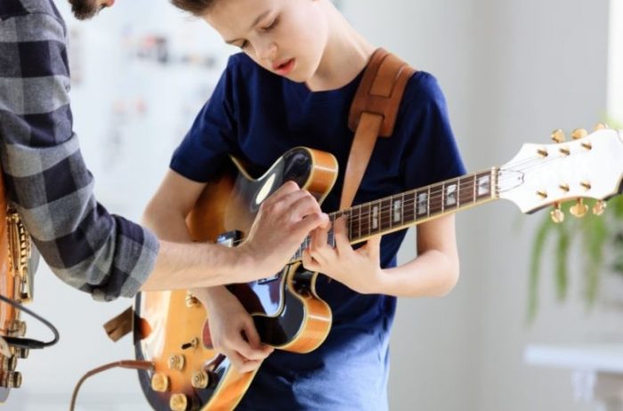 criança tocando Guitarra